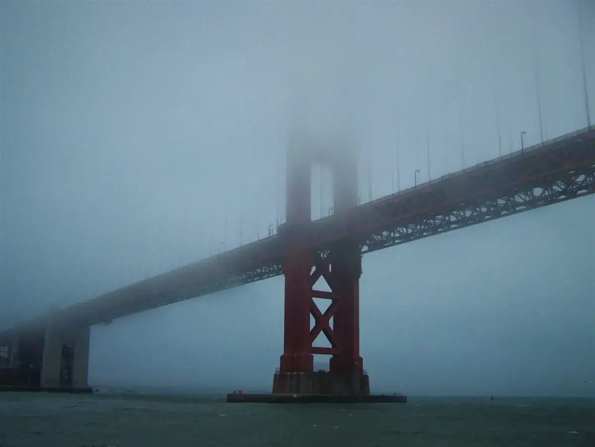 Mglisty, majestatyczny most w San Francisco wyłania się z gęstej mgły, tworząc tajemniczy widok.