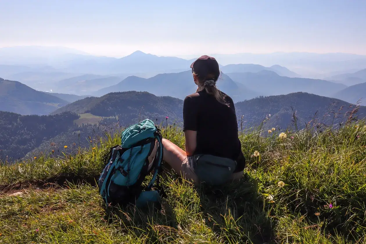 Widok na pasmo górskie Mała Fatra. Turystka z plecakiem odpoczywa na szczycie, podziwiając panoramę.
