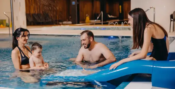 Rodzina cieszy się wodnym szaleństwem w basenie. Idealny hotel dla dzieci w górach, gdzie każdy znajdzie coś dla siebie.