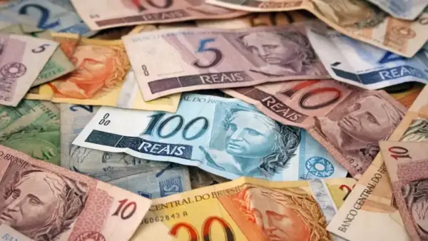 Stosy banknotów w różnych nominałach, w tym 100, 10 i 5 reali. To waluta w Brazylii.
