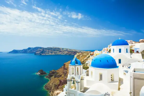 Santorini: białe domy, niebieskie kopuły kościołów i turkusowe morze. Idealne miejsce na tanie wakacje w Grecji.