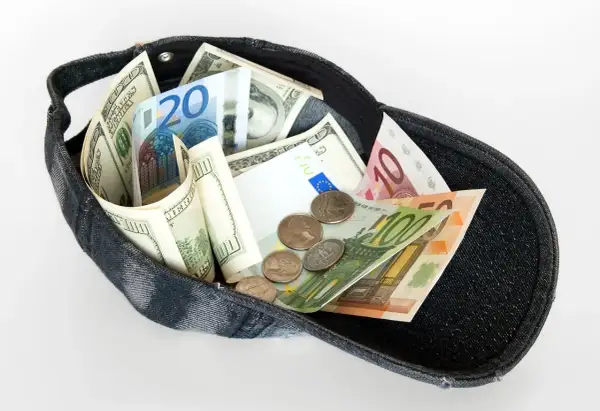 Czapka wypełniona banknotami dolarów i euro. Czy w Turcji można płacić euro? Ta wizualizacja sugeruje, że tak, bo są tam i dolary, i euro.
