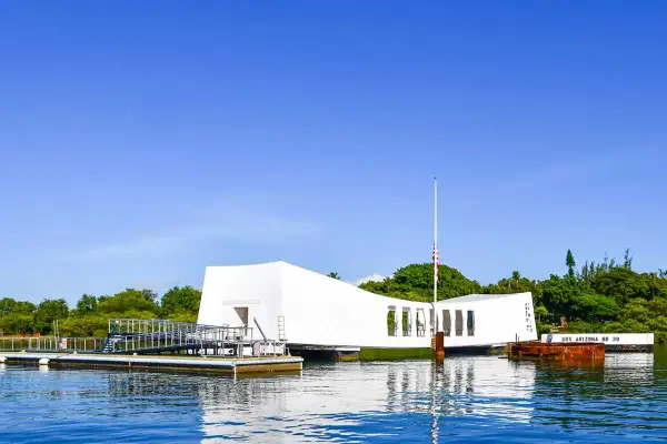 Pomnik USS Arizona w Pearl Harbor, biała konstrukcja nad wodą, upamiętnia tragiczne wydarzenia.