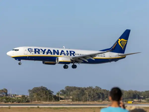 Samolot Ryanair zbliża się do lądowania. Widok z lotniska, gdzie czeka pasażer na odprawę.