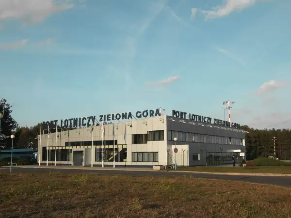 Port Lotniczy Zielona Góra Babimost. Budynek terminala lotniska z napisem na dachu.