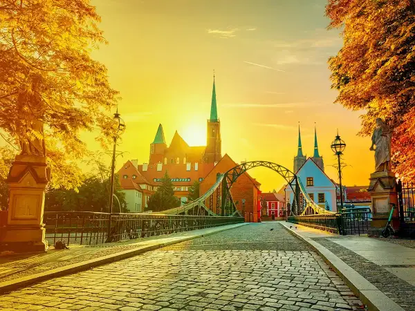 Zachód słońca nad Ostrowem Tumskim we Wrocławiu, idealny na city break z Wrocławia. Most Tumski i katedra w złotym blasku.