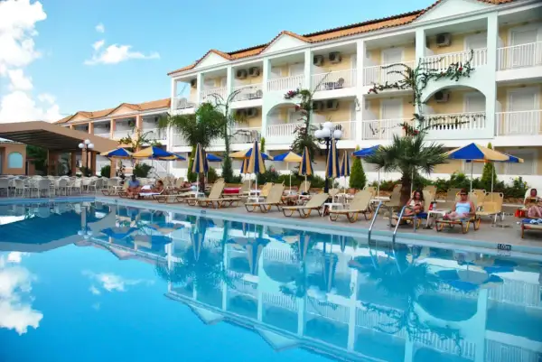 Basen i leżaki przy hotelu Admiral Tsilivi. Goście odpoczywają, a budynek hotelowy odbija się w krystalicznie czystej wodzie.