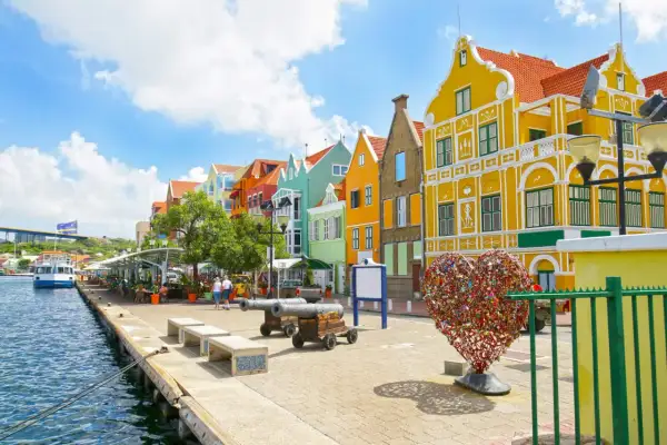 Kolorowe kamienice nad wodą, armaty i serce z kłódek – idealne miejsce na curacao wakacje.