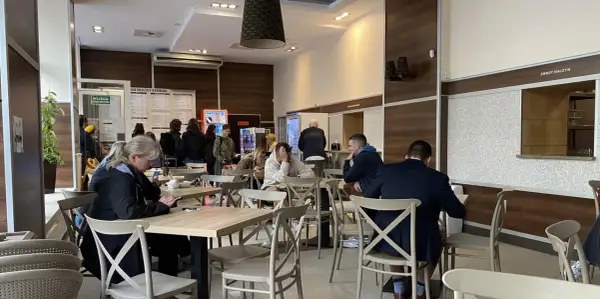 Ludzie jedzą w barze mlecznym, szukając dobrego jedzenia w Warszawie.