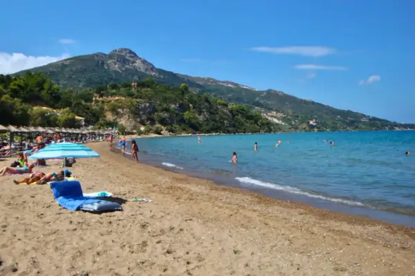 Idealna zakynthos pogoda czerwiec: słońce, plaża i kąpiel w turkusowym morzu. W tle zielone wzgórza.