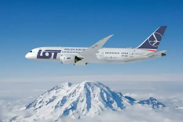 Samolot LOT Polish Airlines leci nad ośnieżonymi górami.