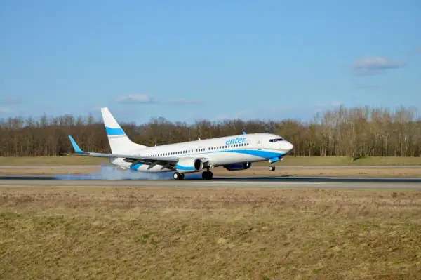 Samolot Enter Air ląduje, wzbijając dym. Ciekawe opinie forum o Enter Air.