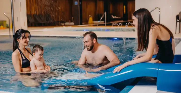Rodzina cieszy się wodnym szaleństwem w basenie. Idealny hotel dla dzieci w górach, gdzie każdy znajdzie coś dla siebie.